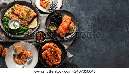 Grilled salmon fish fillet with lemon and strimps. Sea food dishes assorty. Healthy concept. Top view, copy space