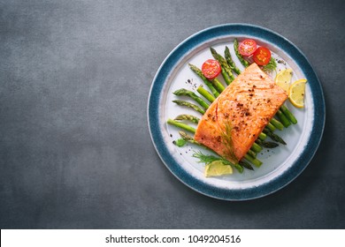 Grilled Salmon Garnished With Green Asparagus And Tomatoes.Top View