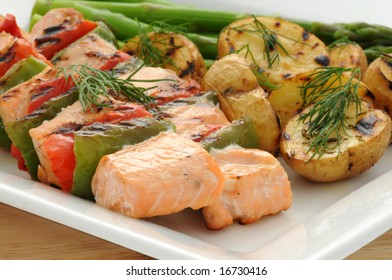 Grilled Salmon Kabobs Served With Vegetables And Potato.