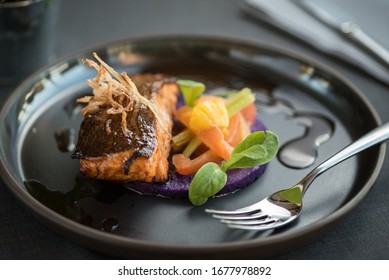 Grilled Salmon On A Round Purple Potato Purée And Fresh Vegetables