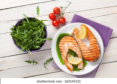 Grilled Salmon And Salad On Wooden Table. Top View