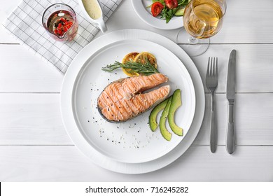 Grilled Salmon Steak With Avocado And Rosemary On Plate