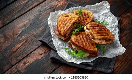 Grilled Sandwich With Turkey, Bacon, Tomato And Cheese On Rustic Wooden Background