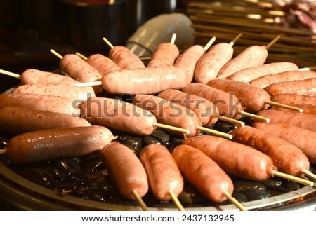 grilled sausage meat stabbing in wooden stick on gridiron street food in China
