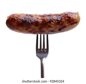 Grilled sausage on a fork against white background