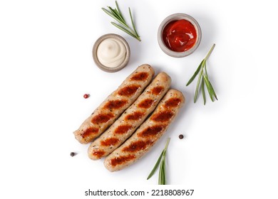 Grilled sausages isolated on white background with rosemary and sauces, top view, copy space. BBQ