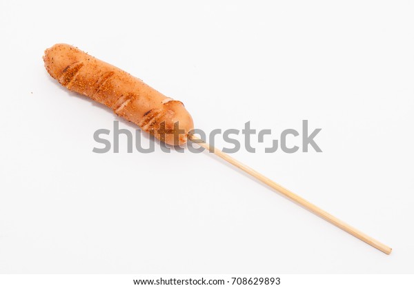 Grilled sausages on wooden stick isolated on\
white background.