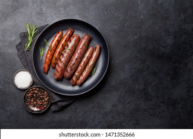 Grilled sausages with rosemary herbs. Top view with copy space