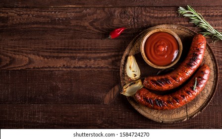 Grilled sausages with spices on wooden background. Top view with copy space. - Shutterstock ID 1584724270