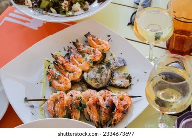 grilled shrimp with local white wine in a tavern on Santorini island in Greece - Powered by Shutterstock