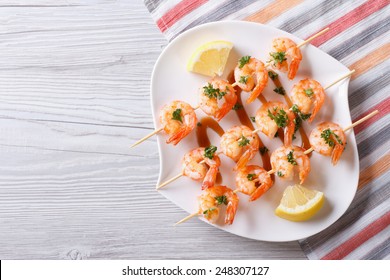 Grilled Shrimp On Skewers With Lemon On A Plate. Horizontal View From Above 