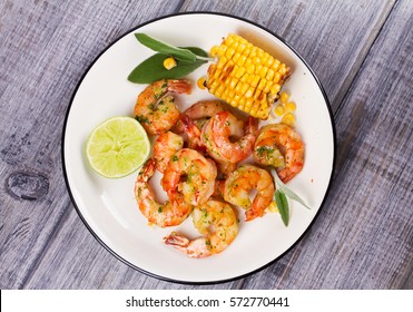 Grilled Shrimps And Corn Garnished With Lime And Sage Leaves. Prawns On White Plate. View From Above, Top Studio Shot