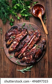 Grilled Sliced Barbecue Pork Ribs, Green Herbs And Tomato Sauce, Top View