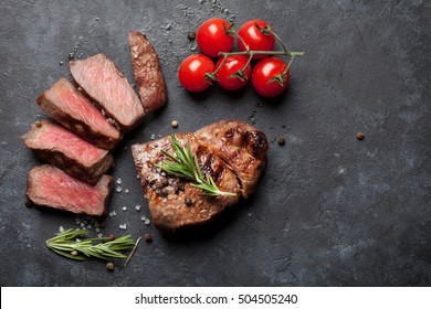 Grilled Sliced Beef Steak And Tomatoes On Stone Table. Top View