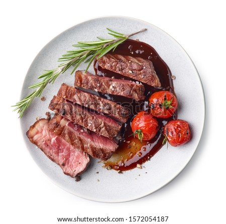 Grilled sliced Beef Steak with tomatoes and rosemary on a plate Isolated on white background top view