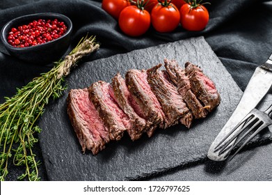 Grilled Sliced Flank Steak With Seasonings And Spices. Black Background. Top View