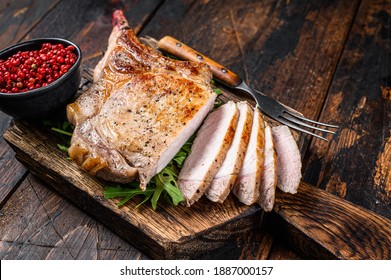 Grilled And Sliced Tomahawk Pork Chop Meat Steak On A Marble Board. Dark Wooden Background. Top View.