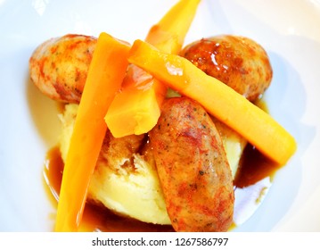 Grilled small sausages with smashed potatoes and glazed carrot slices with  sweet dark beer sauce full of flavors. Tapas style comfort food dish.   - Powered by Shutterstock