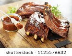 Grilled and smoked ribs with barbeque sauce on a carving board