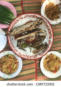 Grilled snakehead fish, papaya salad, bitter gourd, fermented chili paste and fresh vegetables Placed on a mat ready to eat.