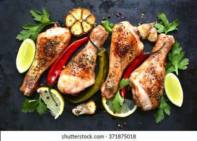 Grilled spicy chicken legs on a black background.Top view. - Powered by Shutterstock