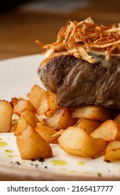 Grilled Steak With Baked Golden Potatoes Served With Crispy Onion On Top On A Brick Background. Delicious Recipe. Pork Fillet Cooked On Skillet For Dinner . Fried Juicy Meat Texture.