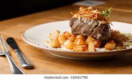 Grilled Steak With Baked Golden Potatoes Served With Crispy Onion On Top On A Brick Background. Delicious Recipe. Pork Fillet Cooked On Skillet For Dinner . Fried Juicy Meat Texture.