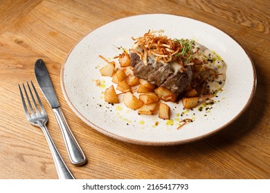 Grilled Steak With Baked Golden Potatoes Served With Crispy Onion On Top On A Brick Background. Delicious Recipe. Pork Fillet Cooked On Skillet For Dinner . Fried Juicy Meat Texture.