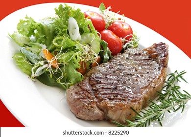 Grilled Steak With Salad.  Porterhouse Or New York Strip Steak, Grilled, With Rosemary.  Served With Salad.