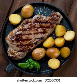 Grilled Striploin Steak With Potato In A Frying Pan, Top View