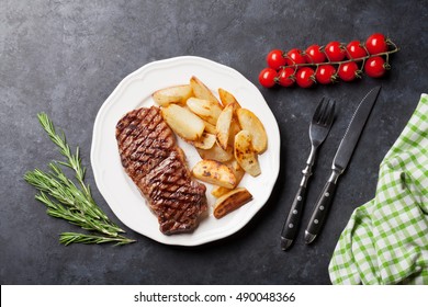 Grilled Striploin Steak With Roasted Potato On Plate Over Stone Table. Top View