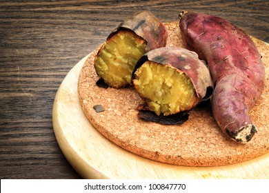 Grilled Sweet Potatoes On Cork Board And Wooden Surface