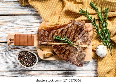 Grilled T Bone Steak On A Chopping Board. Cooked Tbone Beef. White Wooden Background. Top View