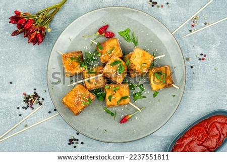 Grilled tofu cheese skewers with sauce on the plate