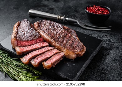 Grilled top sirloin or cup rump beef meat steak on marble board. Black background. Top view - Shutterstock ID 2105932298