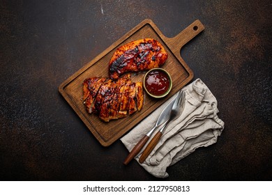 Grilled Turkey Or Chicken Marinated Fillet With Red Sauce Served And Sliced On Wooden Cutting Board On Stone Brown Background From Above, Poultry Breast Barbecue 