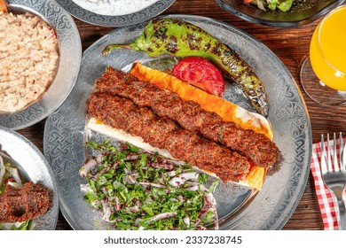Grilled Turkish Adana, Urfa Kebab with grilled vegetables, onion and rice on plate. Adana durum.