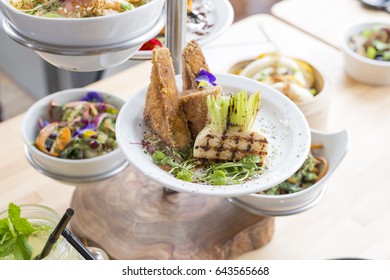 Grilled Turnip With Fried Tofu Slices And Other Dishes On Tiered Server