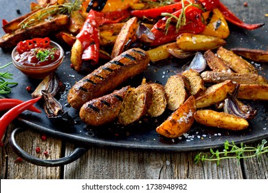 Grilled vegan sausages with hot sauce, potato wedges and vegetables