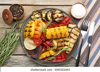 Grilled vegetable on brown cutting board with rosemary, salt and pepper - Powered by Shutterstock