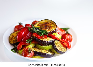 
Grilled vegetables on a white plate. Peppers, tomatoes, zucchini, eggplant, rosemary and herbs are nicely served on a plate. Baked red bell pepper with eggplant. Restaurant serving vegetables - Powered by Shutterstock