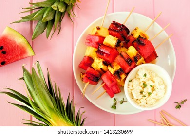 Grilled Watermelon And Pineapple Fruit Kabobs With Feta. Above View On A Pink Wood Background. Summer Food Concept.