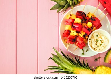 Grilled Watermelon And Pineapple Fruit Kabobs. Top View Side Border On A Pink Wood Background. Summer Food Concept.