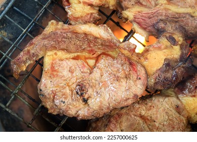Grilling meat steak on the hot oven - Shutterstock ID 2257000625