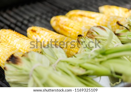 Grilling mexican street corn elote on outdoor gas grill.