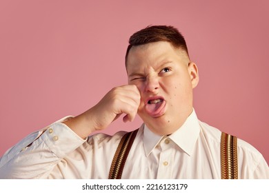 Grimace. Studio Shot Of Big Obese Teen Boy In White Shirt And Shorts With Suspenders Isolated Over Pink Background. Concept Of Health, Youth, Emotions, Retro Vintage 70s, 80s American Style. Weird