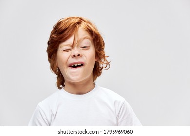 grimacing redhead boy with open mouth squints eyes cropped view gray  - Shutterstock ID 1795969060