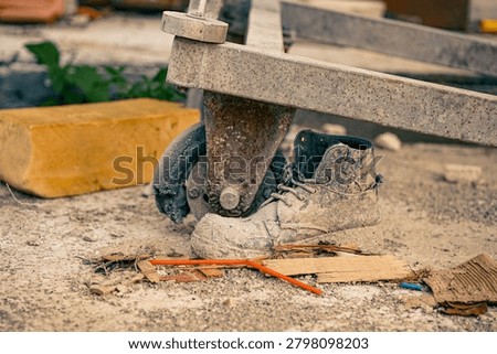 Grimy Worker Boot with Rusty Cart Wheel