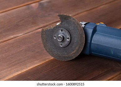 A Grinder With A Broken Blade On A Wooden Table. The Danger Of Using Power Tools.