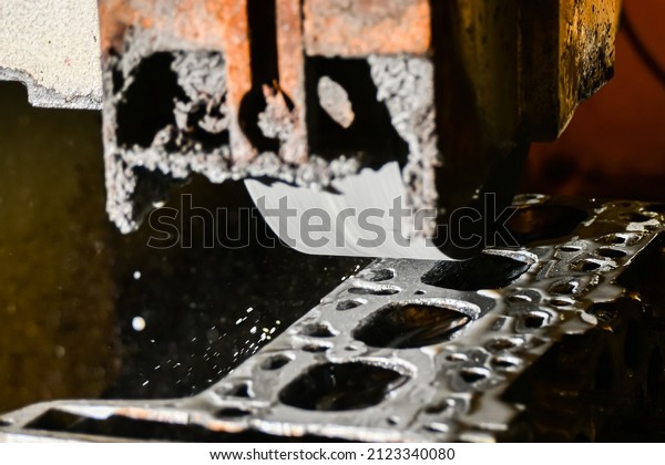 Grinding the cylinder head of a car engine on a\
water-cooled surface\
grinder.